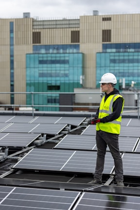 a man standing on top of a roof next to solar panels