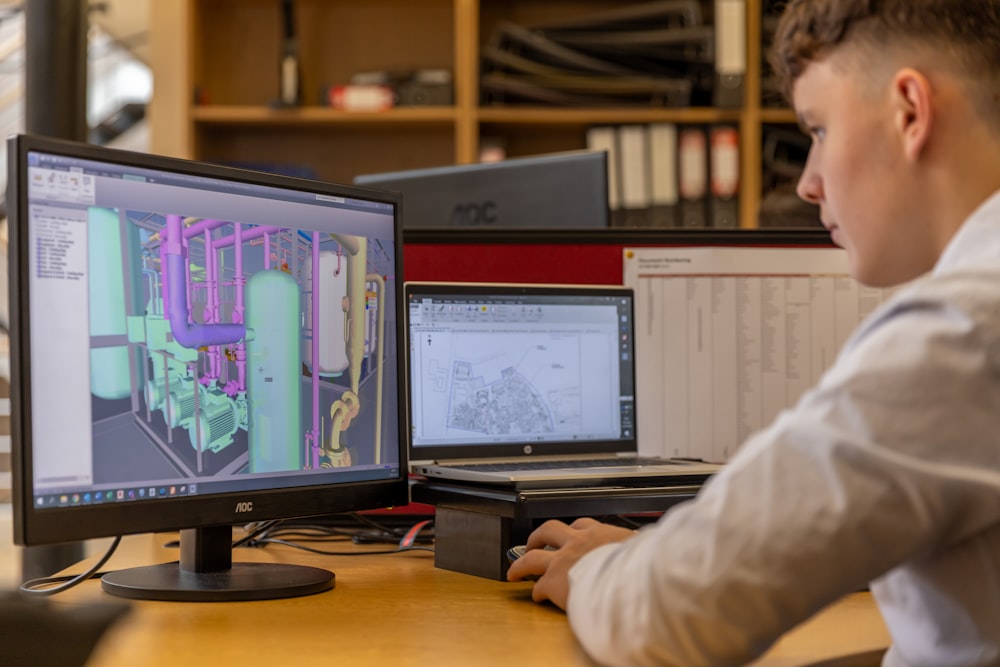 Un hombre sentado en un escritorio mirando la pantalla de una computadora