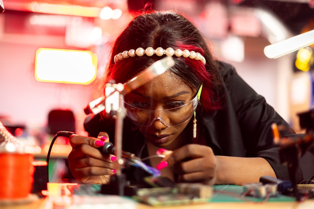 a woman working on a piece of electronics