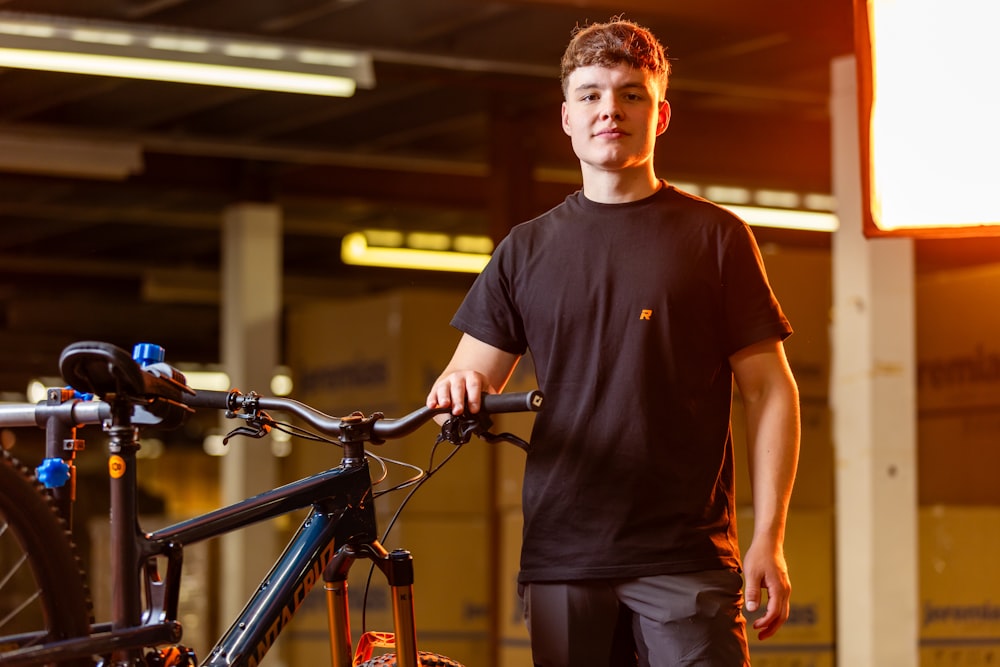 a man standing next to a bike in a garage