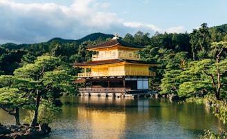 a pagoda in the middle of a lake surrounded by trees