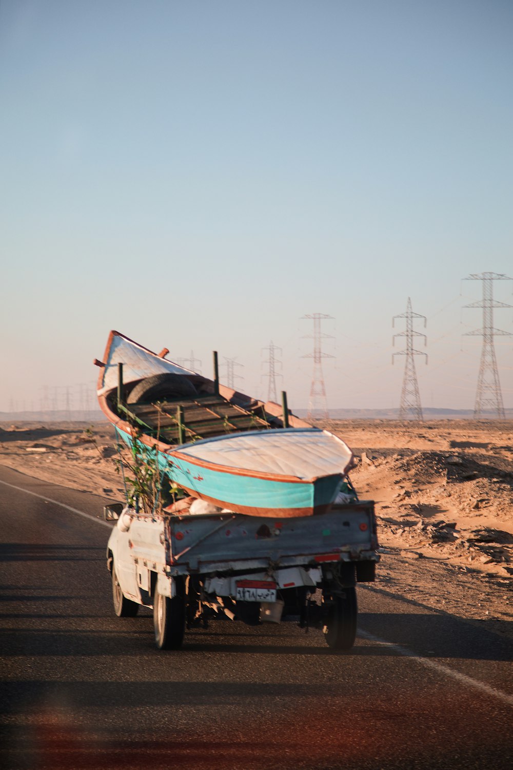 a boat on the back of a truck on a road
