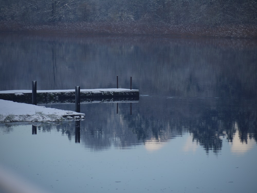 a body of water surrounded by snow covered ground