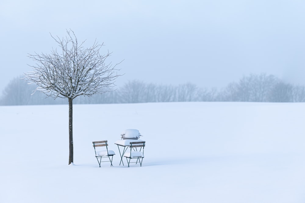 a couple of chairs and a table in the snow