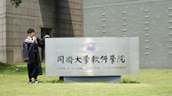a man standing next to a sign in front of a building