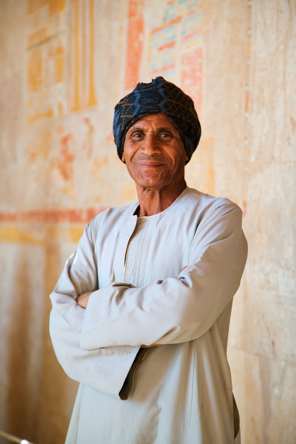 a man with a turban standing in front of a wall