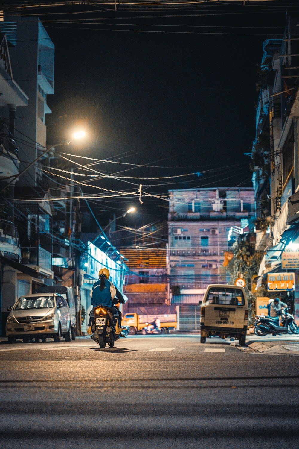 a man riding a motorcycle down a street at night