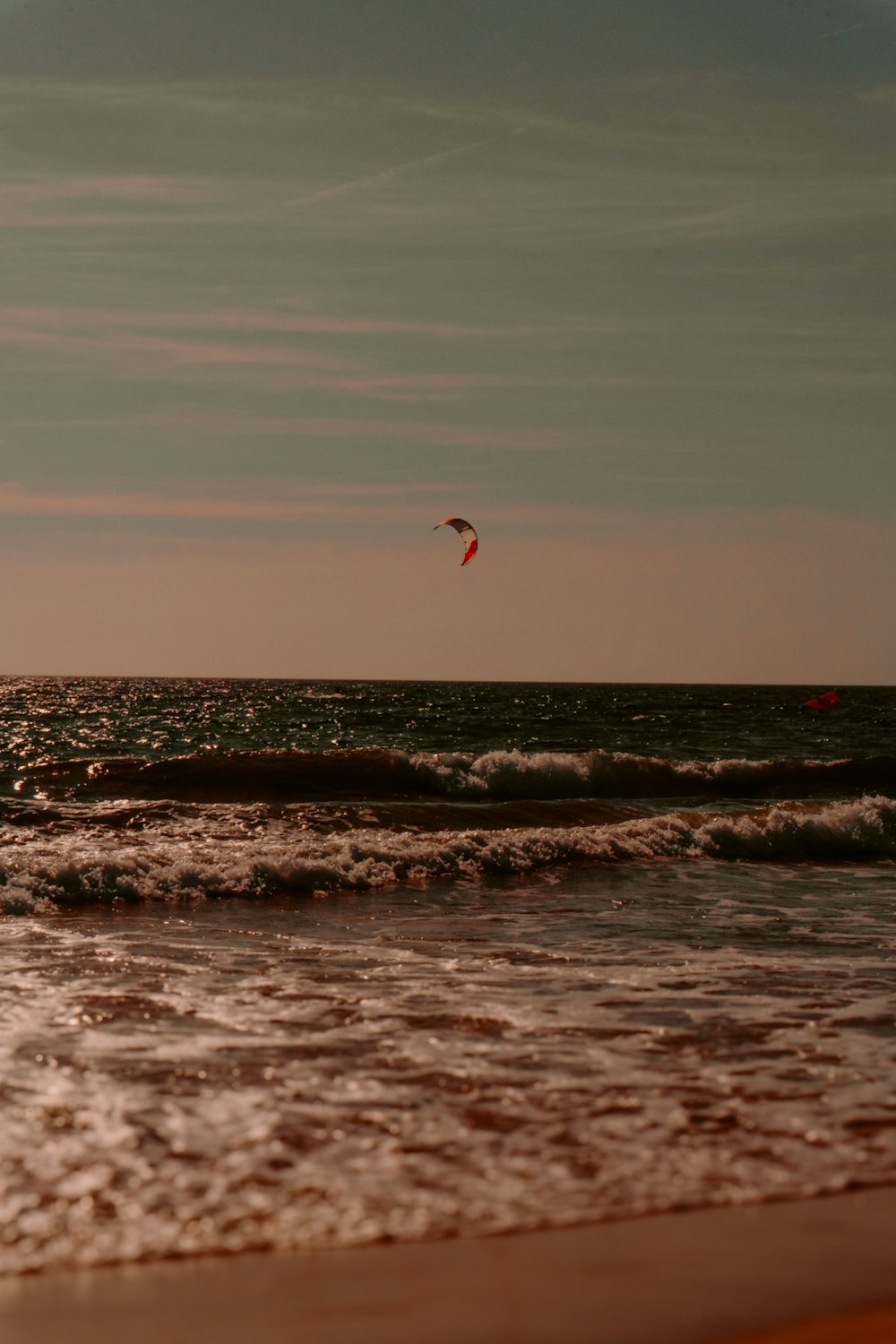 a person flying a kite on the beach