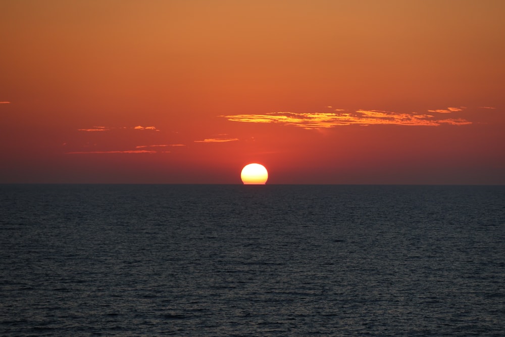 the sun is setting over the ocean on a clear day