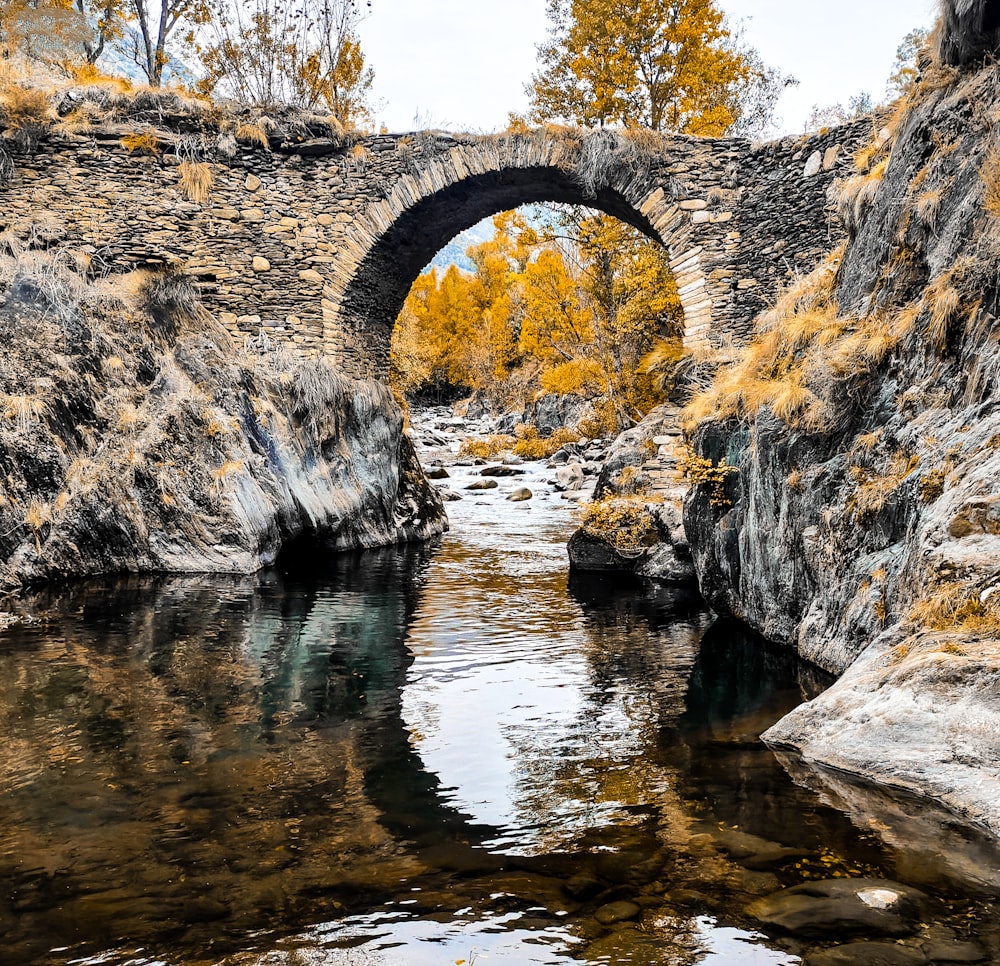 a stone bridge over a river surrounded by rocks