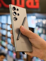 a person holding a silver cell phone in their hand