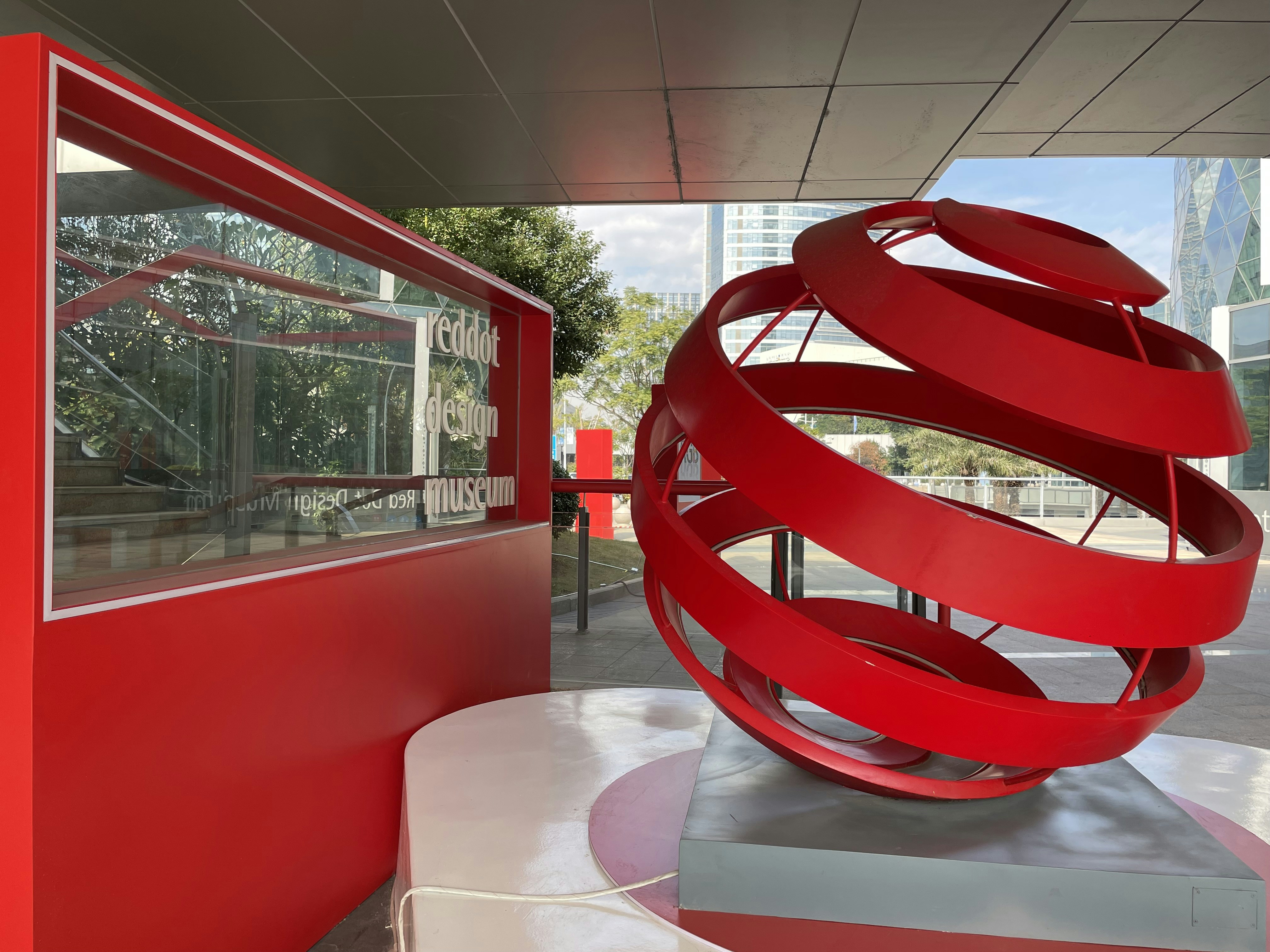 A red sculptural installation in front of a building