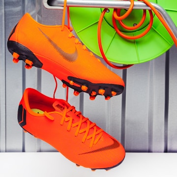 a pair of orange shoes hanging from a rack