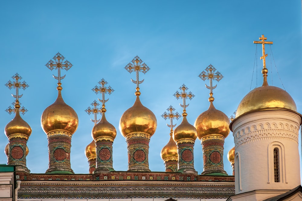 a row of golden domes on top of a building
