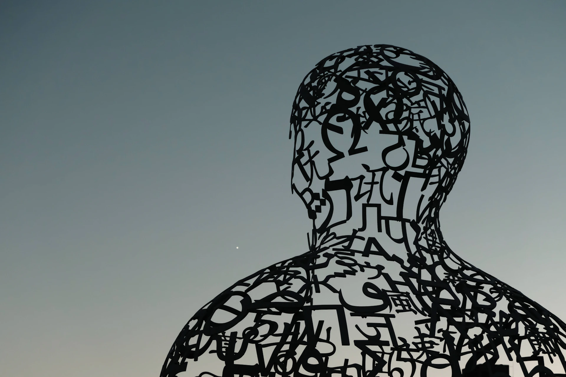 a sculpture of a man with letters all over it