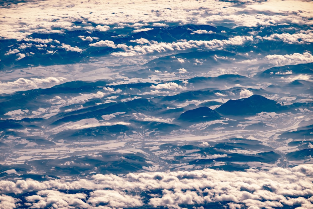 uma vista de nuvens e montanhas de um avião