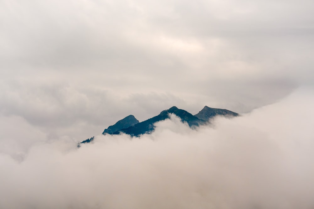 a mountain covered in clouds with a sky background
