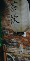 a chinese lantern hanging in front of a brick wall
