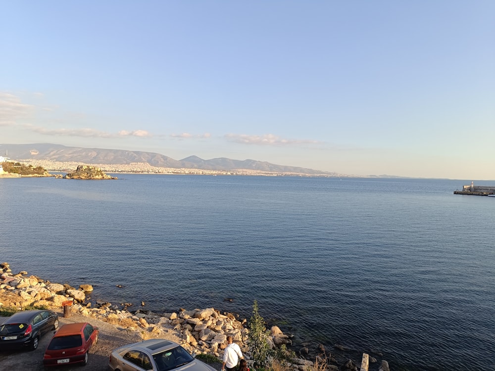 a body of water with cars parked on the side of it