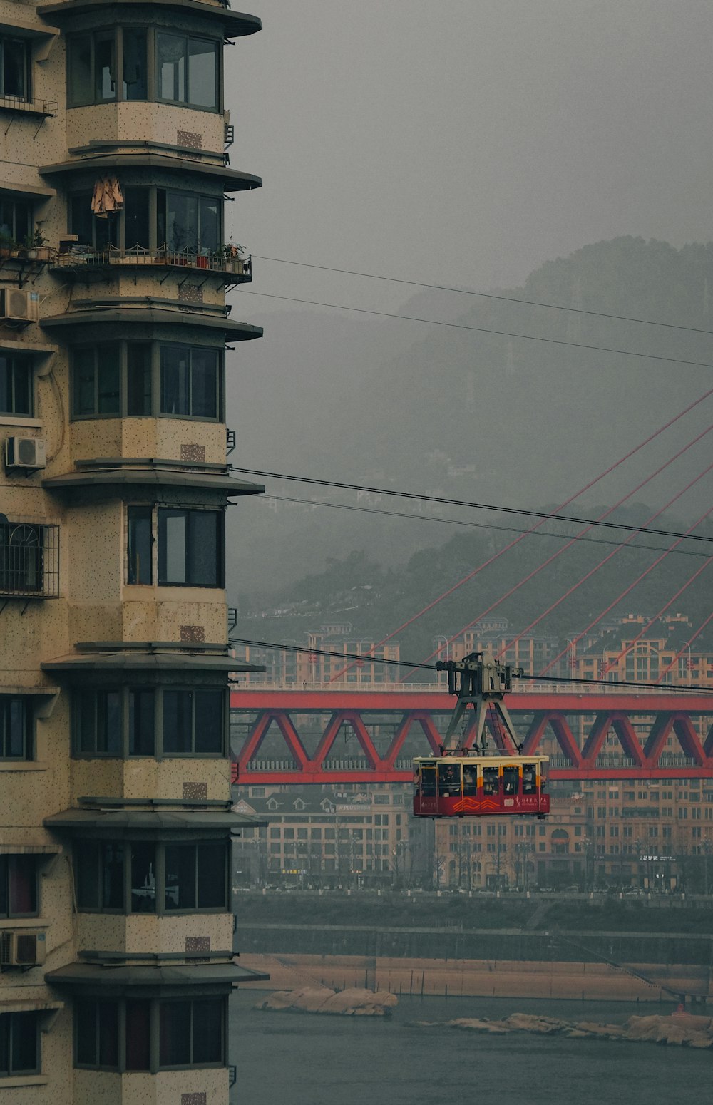 a red cable car going over a bridge
