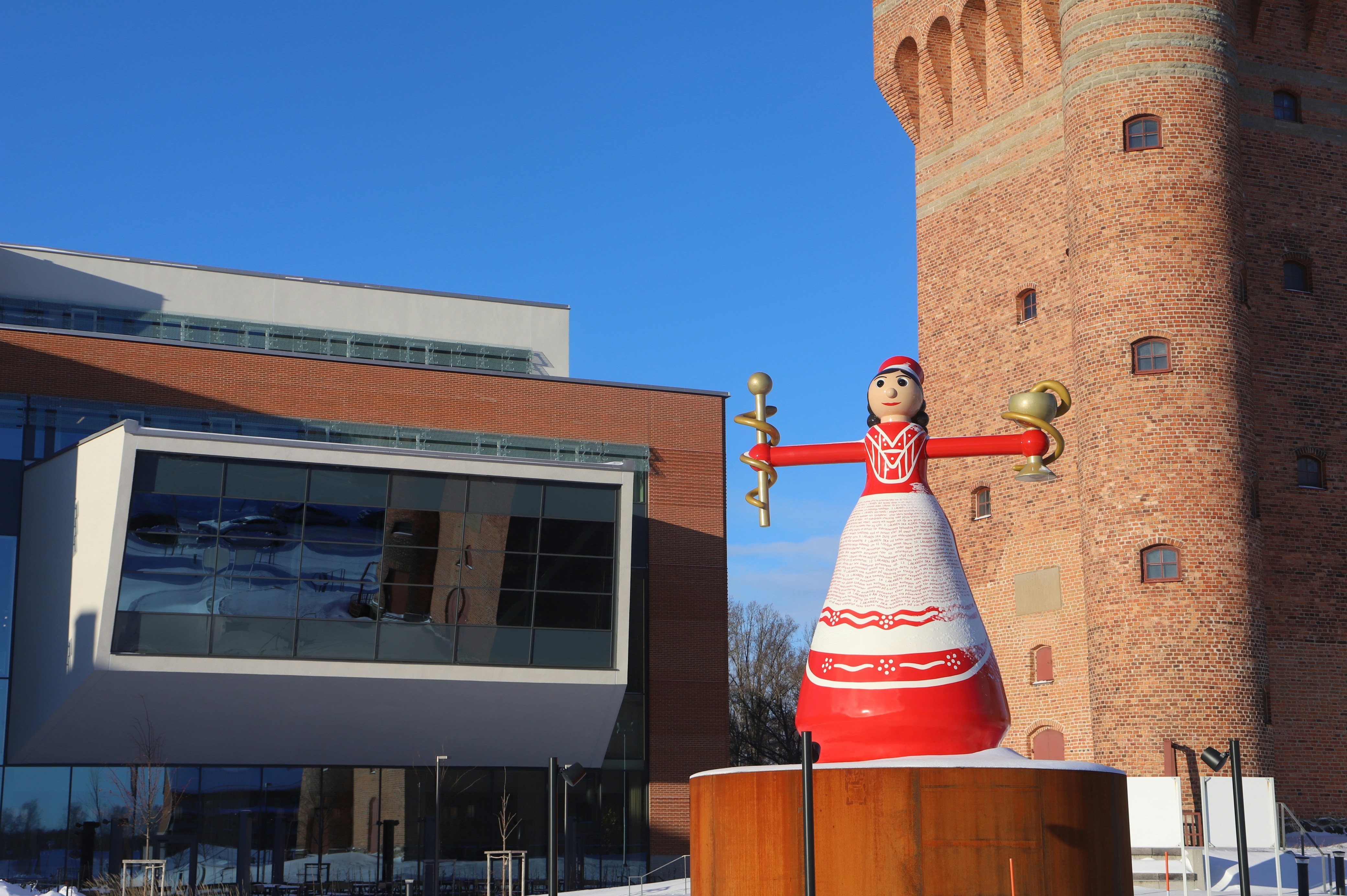 a statue of a person holding a spoon in front of a building