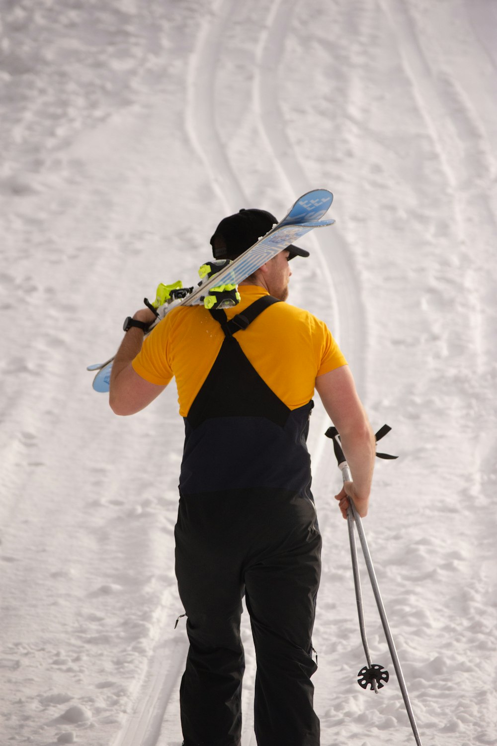 a man with skis and ski poles walking in the snow