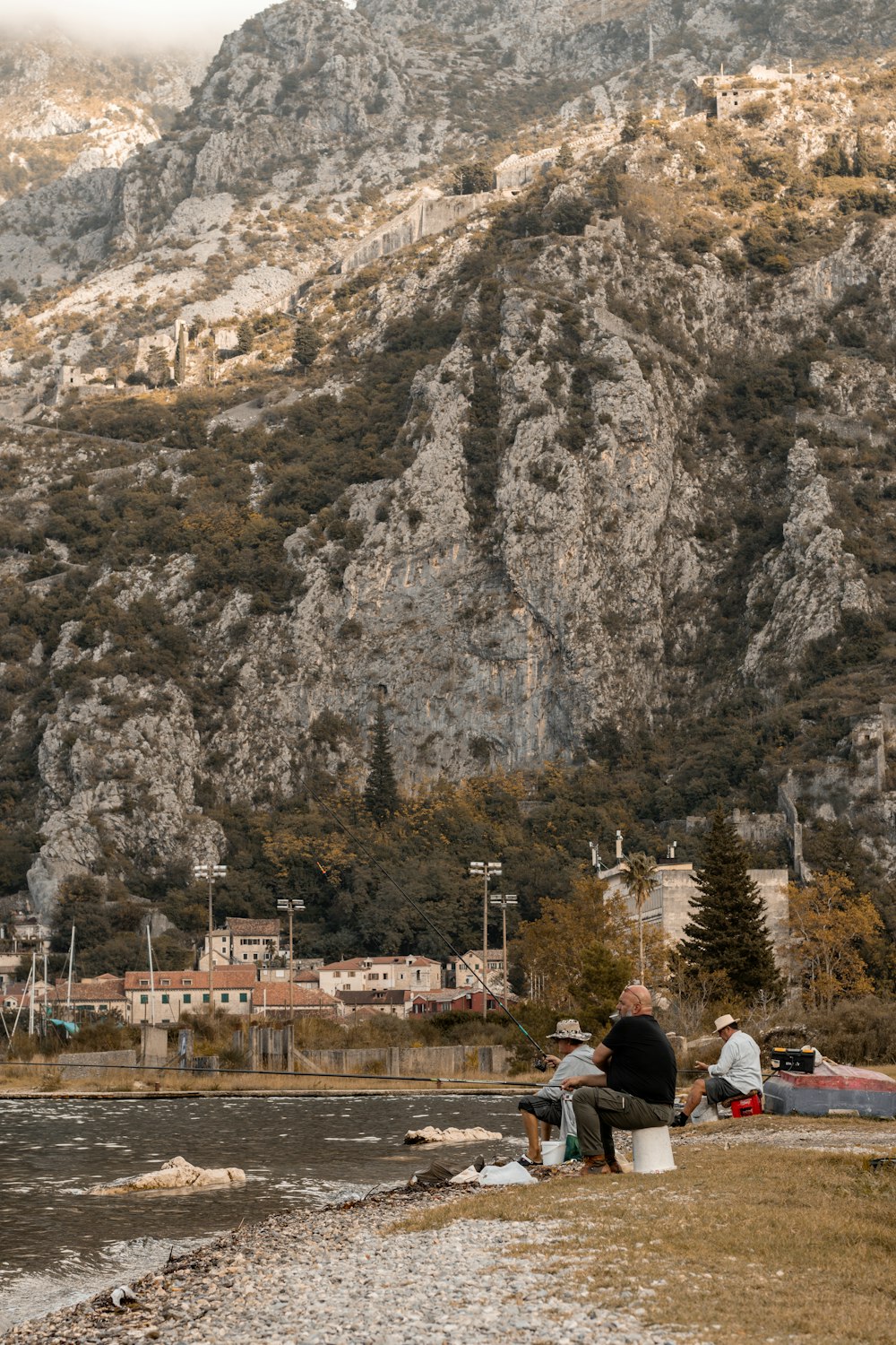 a couple of people sitting on a bench near a body of water