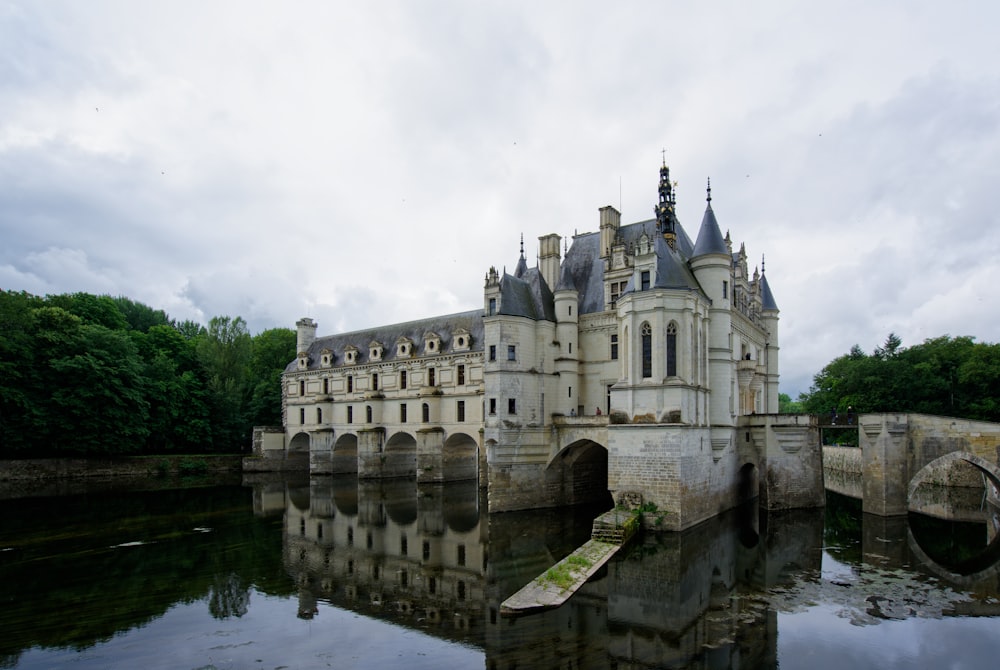 un grand château assis au-dessus d’un plan d’eau