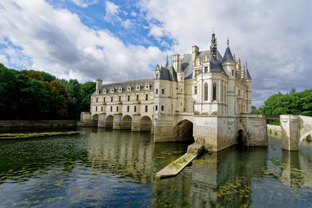 un grand château assis au-dessus d’un plan d’eau