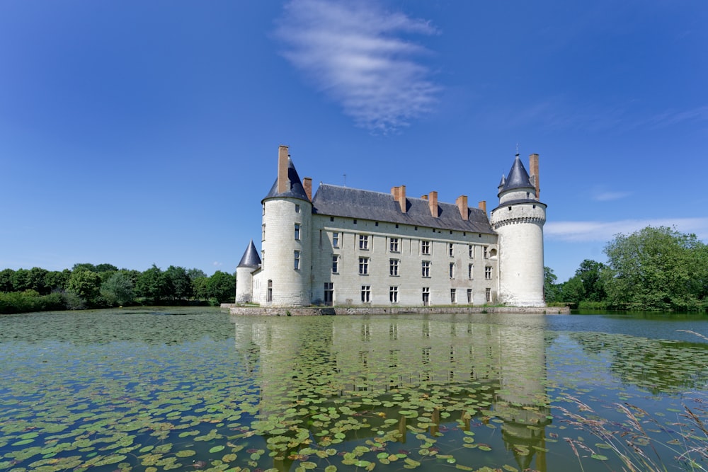 a large white castle sitting on top of a lake