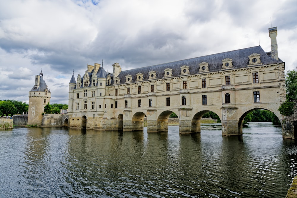 a large building sitting on top of a river next to a bridge