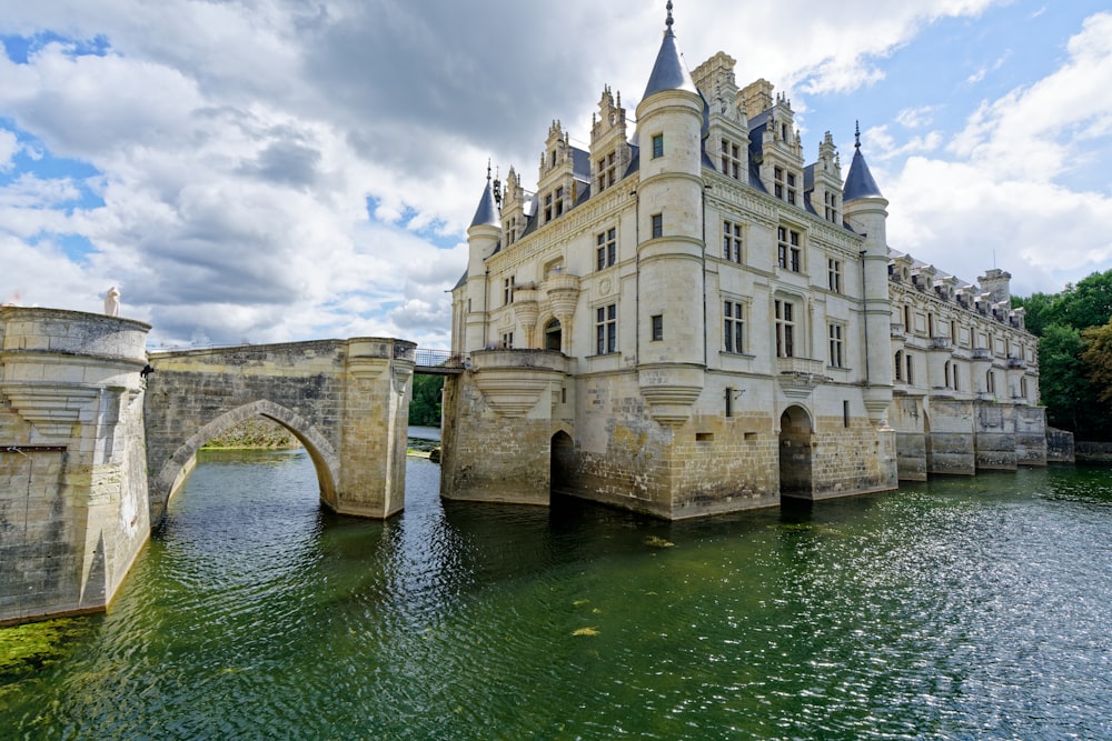 a large building sitting on top of a river next to a bridge