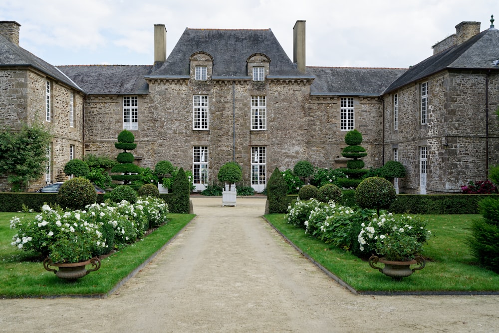 a large stone building with a garden in front of it