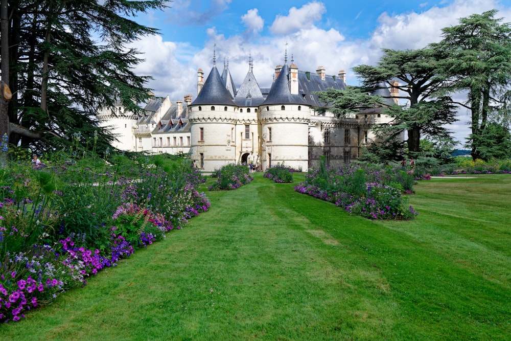 a large white castle surrounded by lush green grass