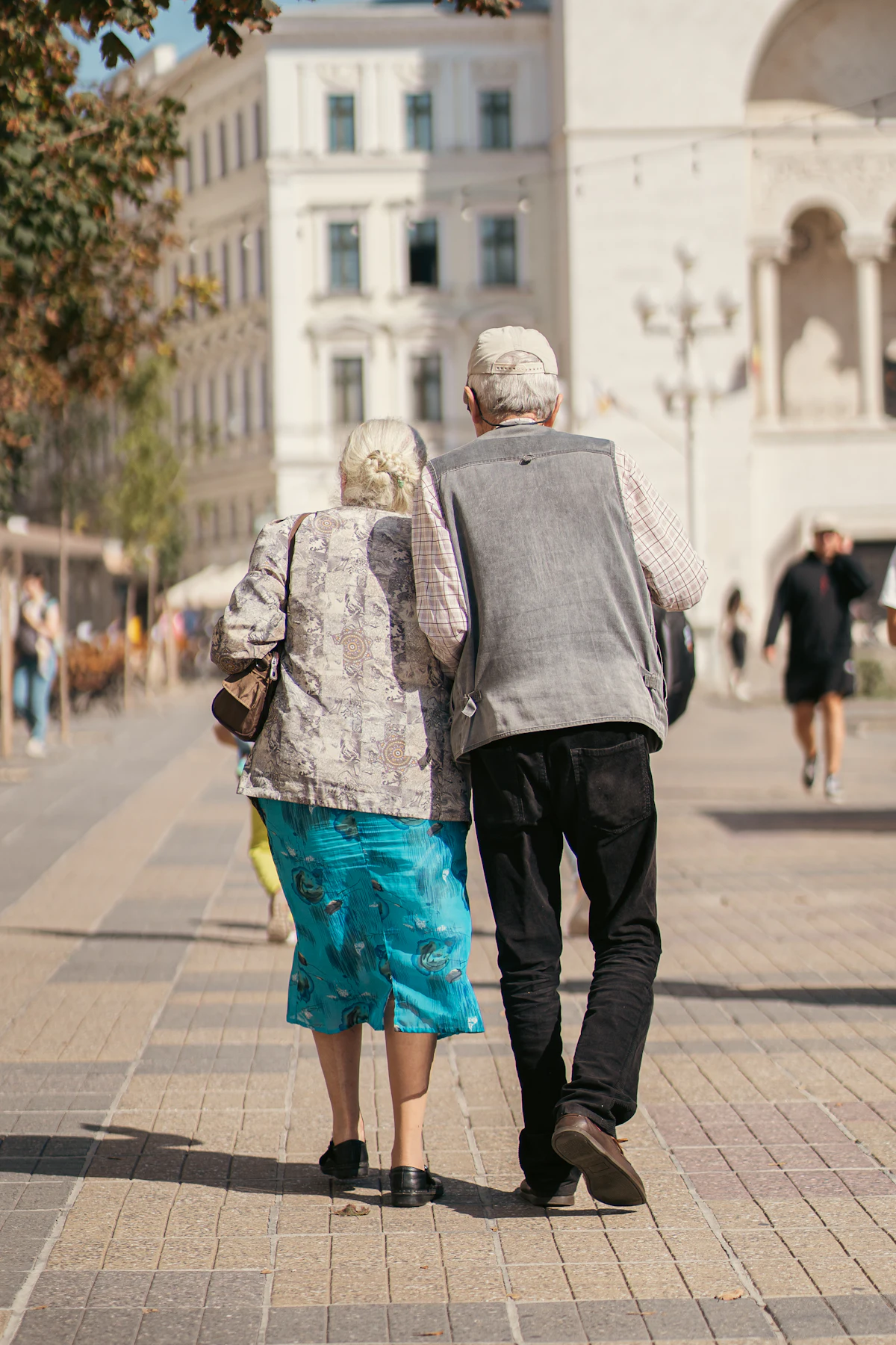 Two people walking together down a quiet street