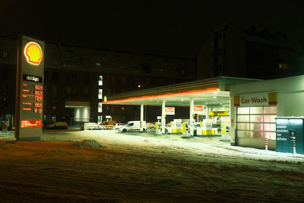 una stazione di servizio di notte con la neve a terra