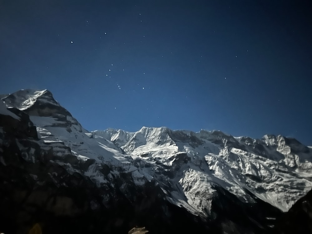 a view of a snow covered mountain at night