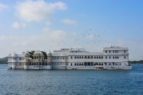 a large white building sitting on top of a body of water