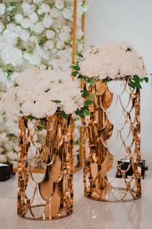 a couple of vases with flowers on top of a table