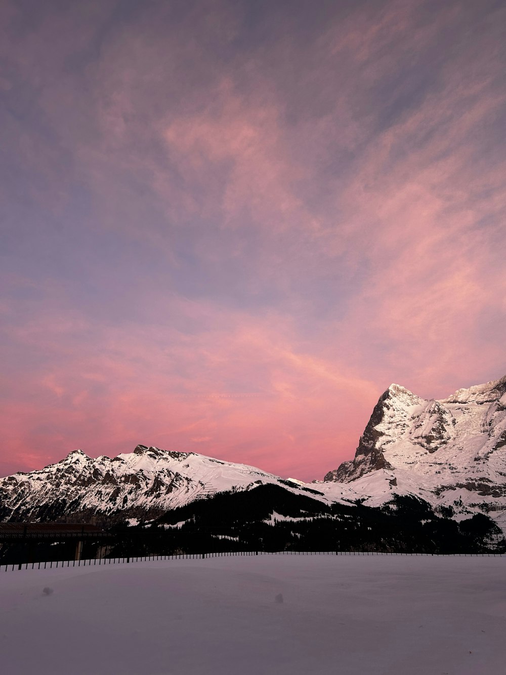 a snow covered mountain with a pink sky in the background