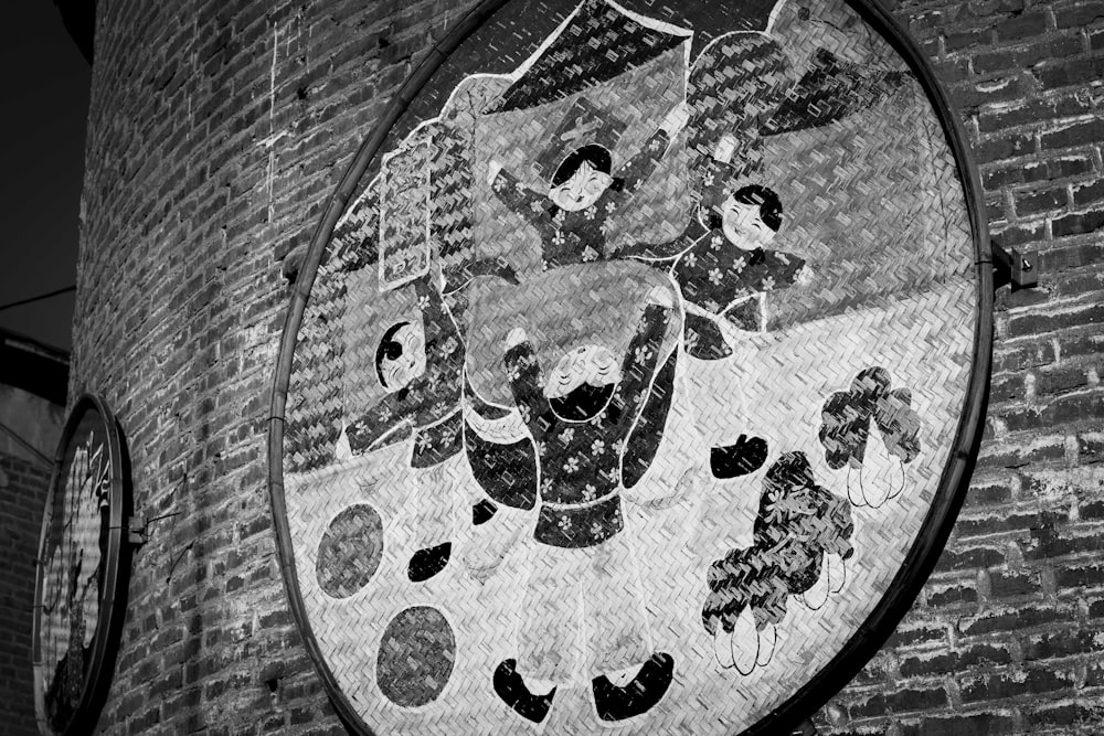 a black and white photo of a clock on a brick wall