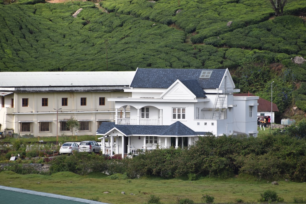 a large white house sitting on top of a lush green hillside