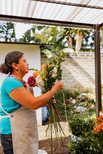 a woman holding a bunch of flowers in her hands