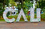 a large metal sign that is in the middle of a park