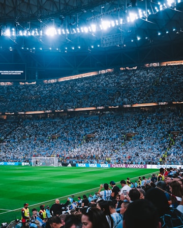 Packed arena crowd watching a game under bright stadium lights