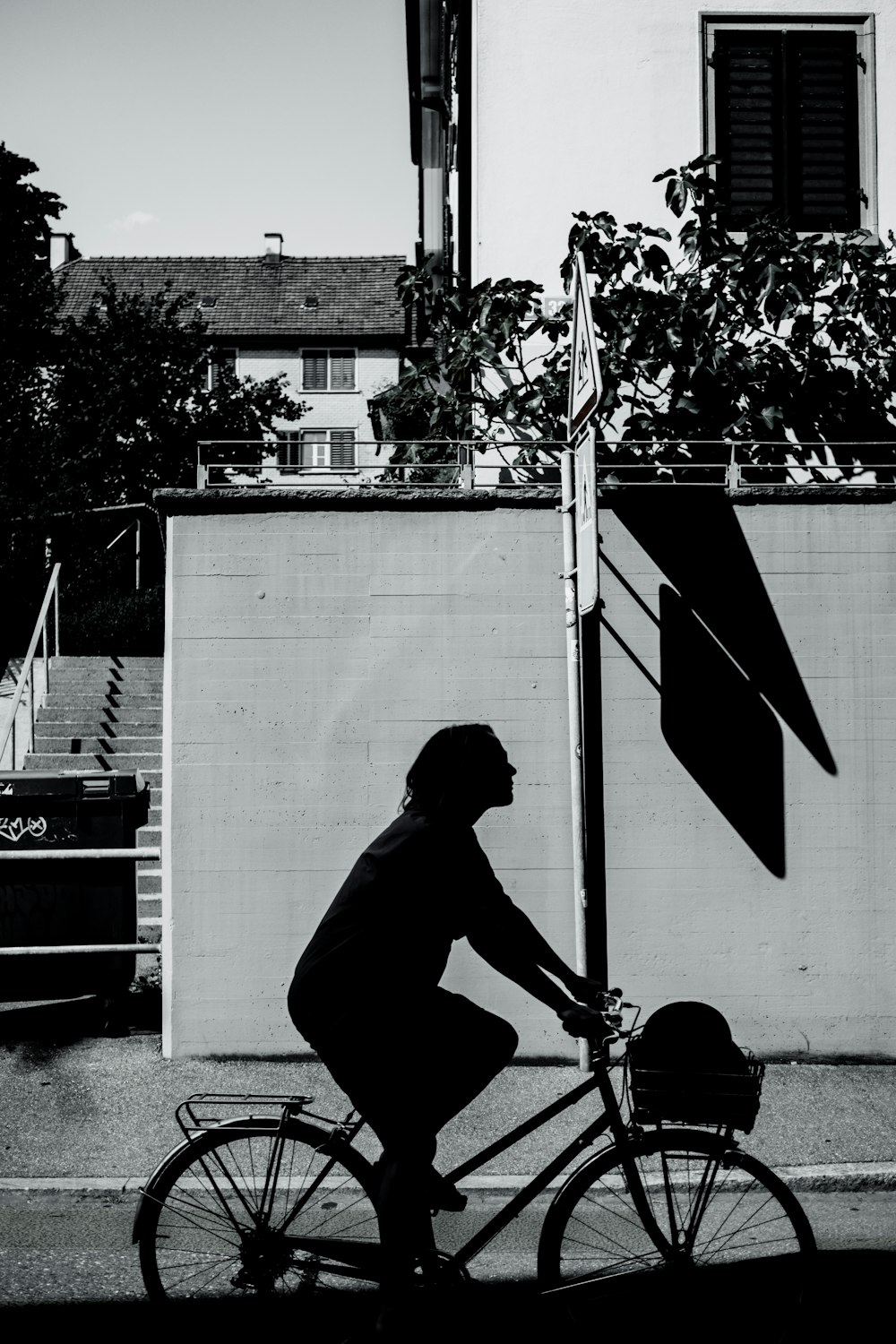 a man riding a bike down a street next to a tall building