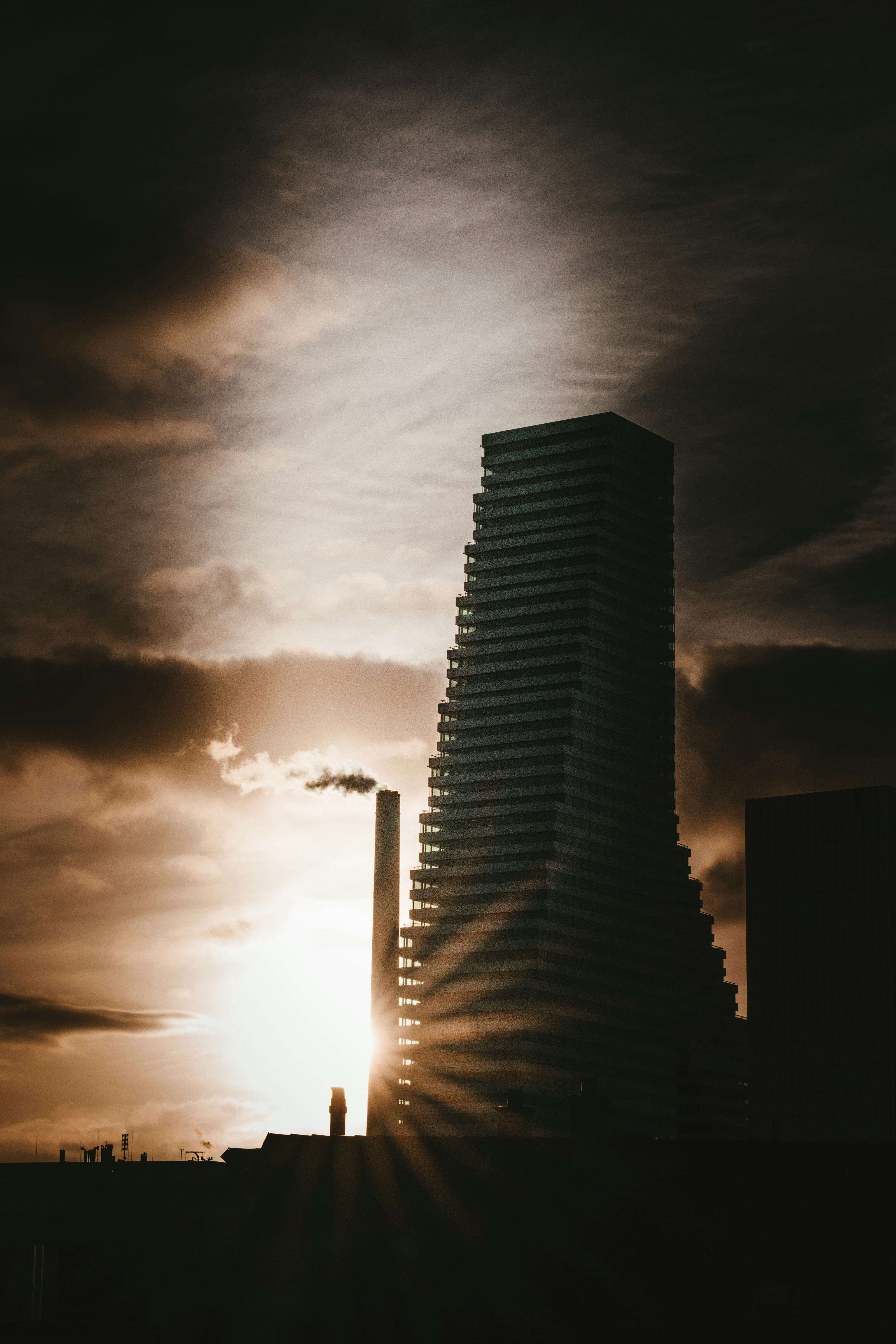 a very tall building sitting under a cloudy sky