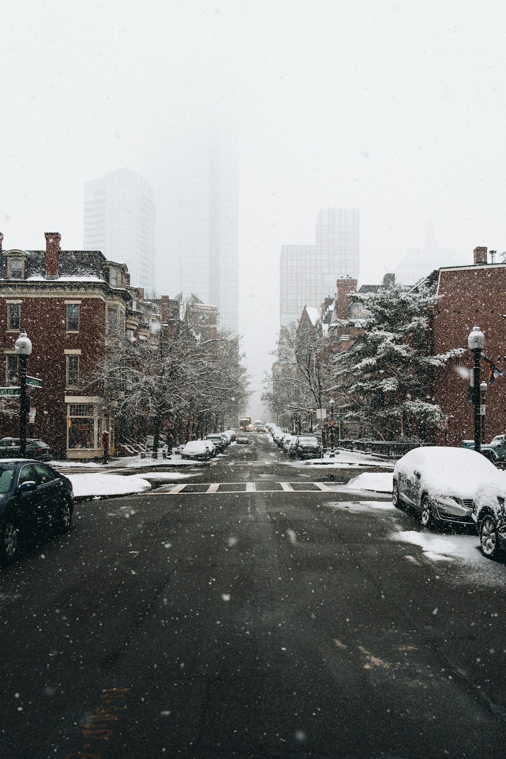 a snowy street with cars parked on the side of it