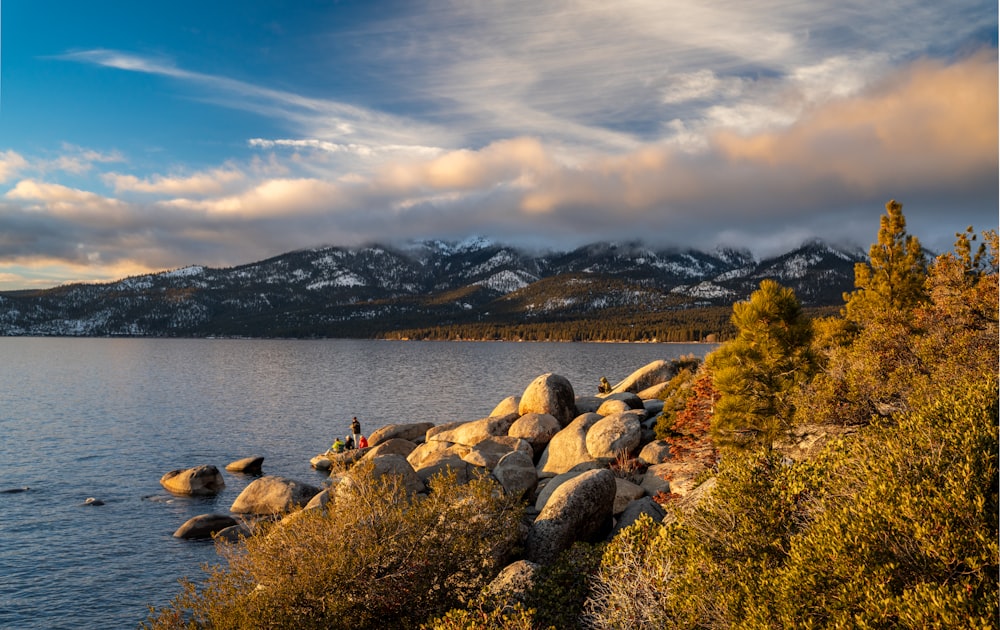 a person standing on rocks near a body of water