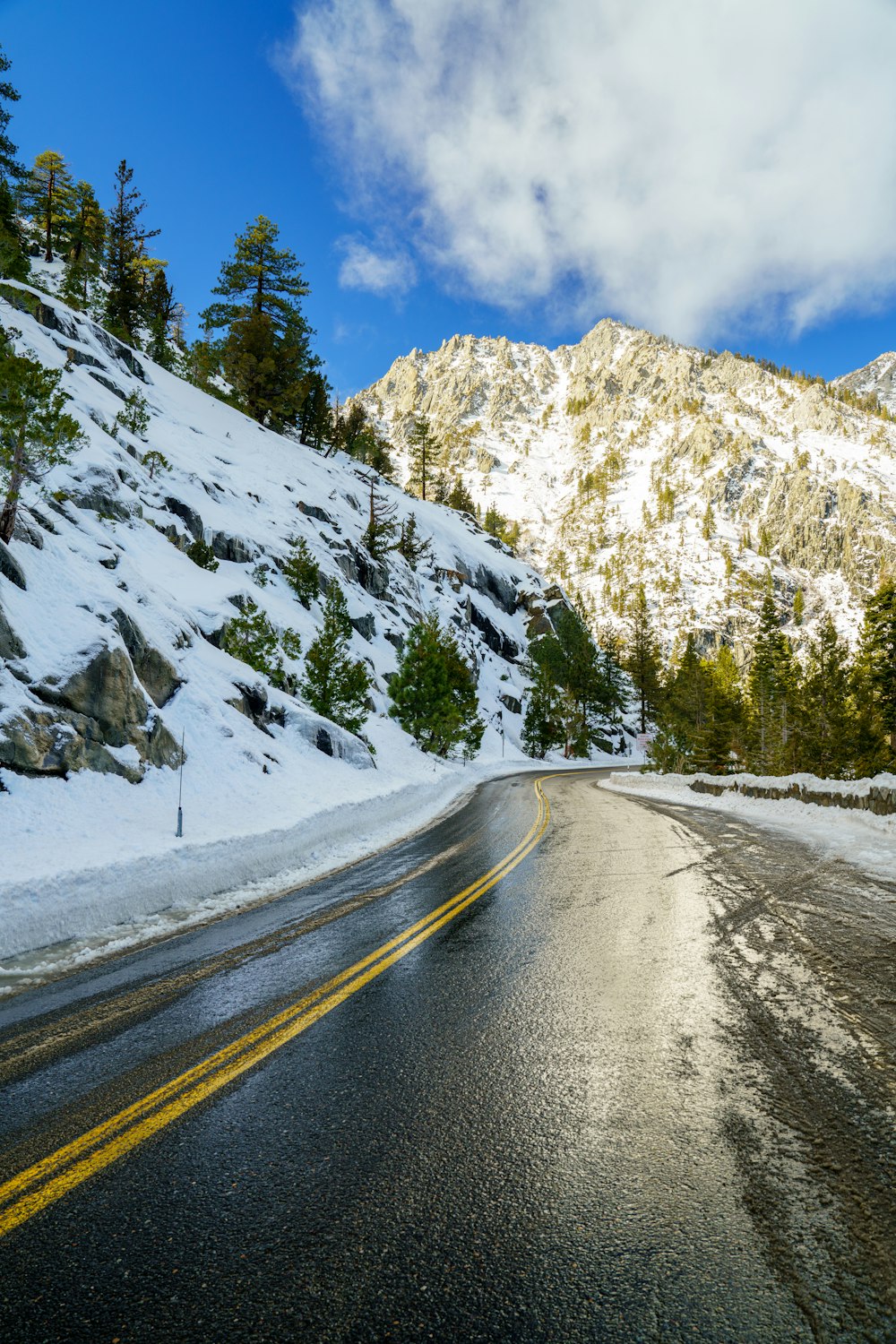 a snow covered road with a mountain in the background